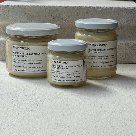 ρία χειροποίητα αρωματικά κεριά Peanut Butter Banana Fudge σε γυάλινα δοχεία διαφορετικών μεγεθών (90gr, 170gr, 240gr) με μεταλλικά καπάκια.